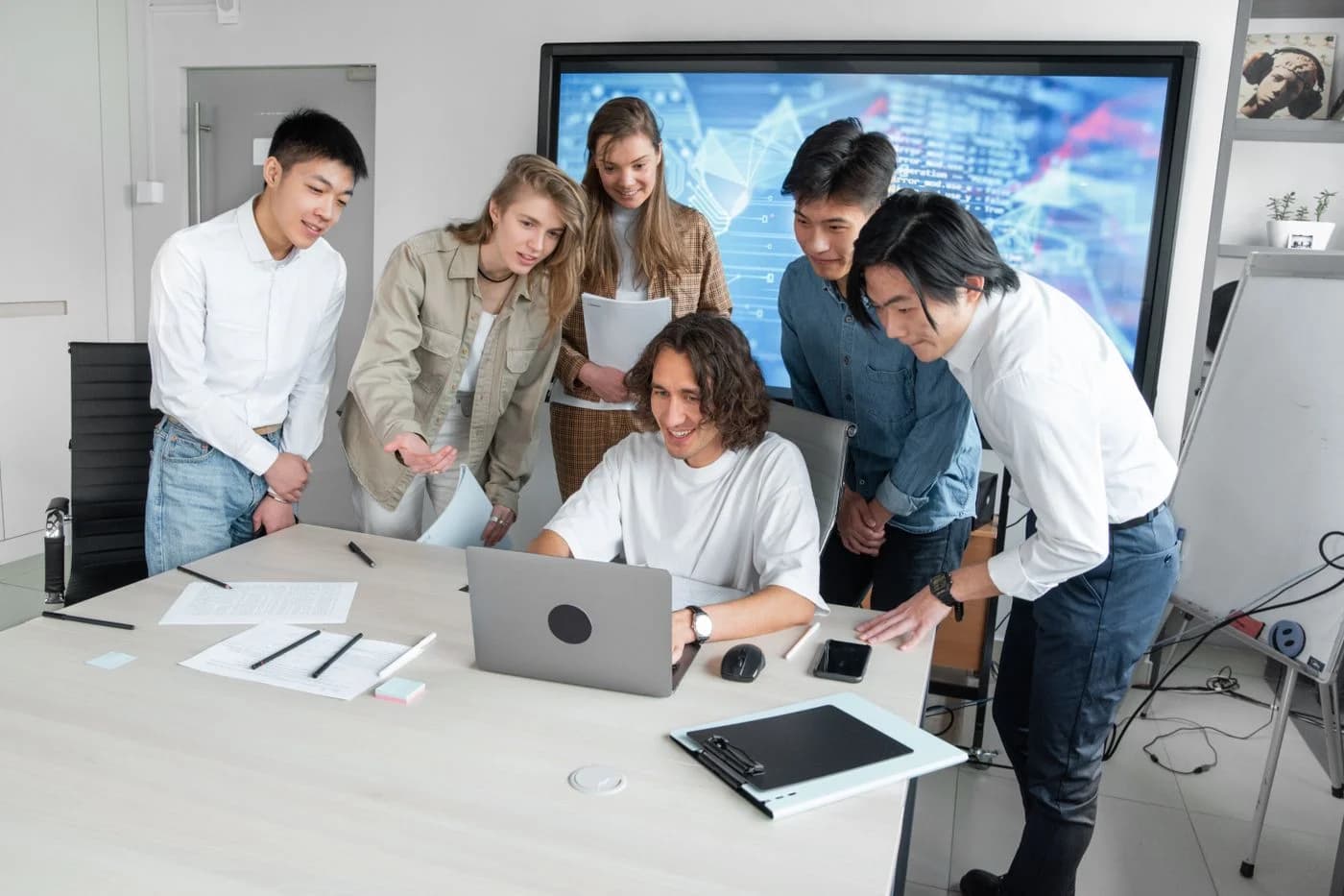 Un groupe échange autour d’un ordinateur et de documents de travail
